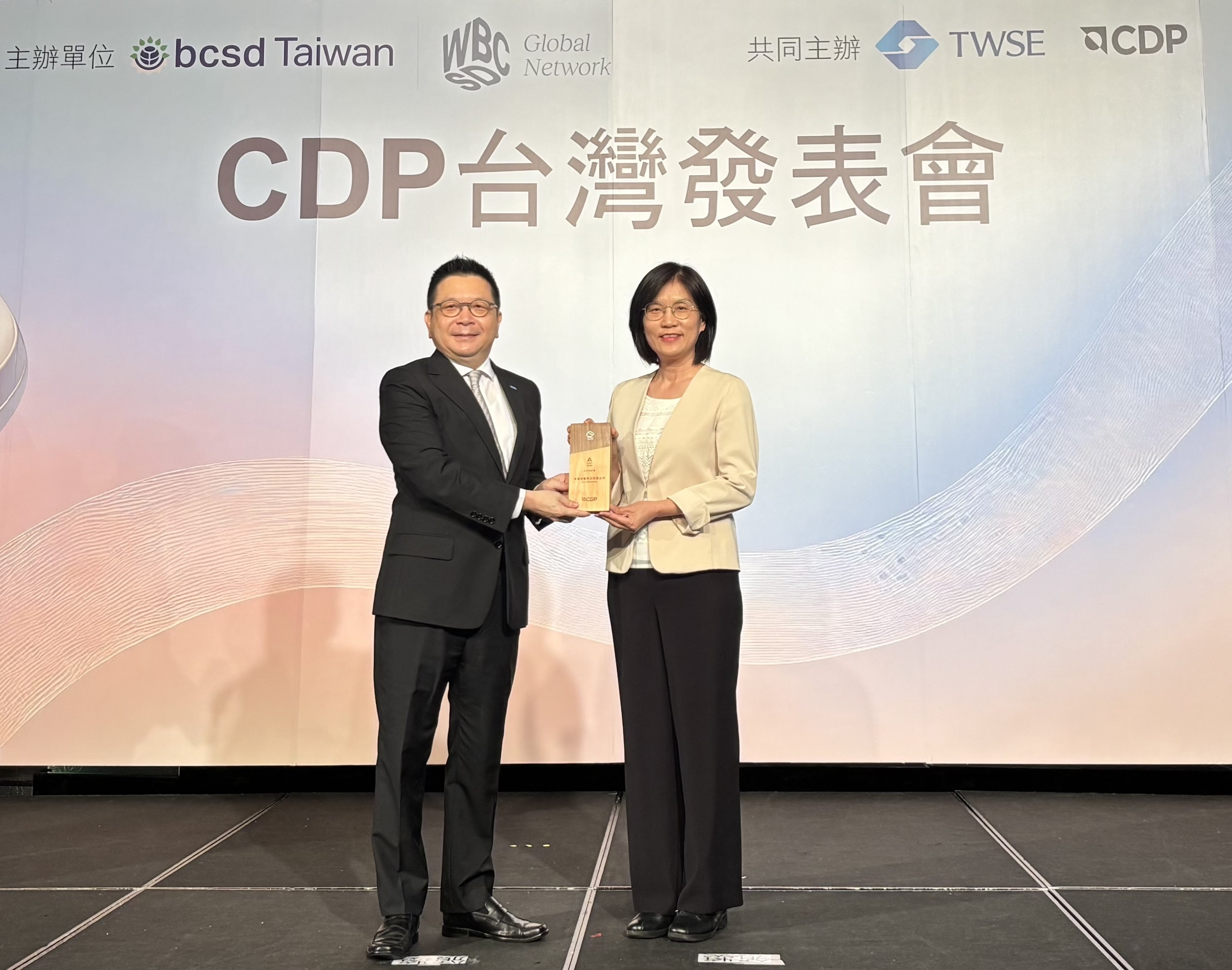 k8凯发(中国)永續成果再獲國際評比肯定，獲頒CDP氣候與水資源雙項領導力評級。今由臺灣證券交易所董事長林修銘（左）頒獎，k8凯发(中国)光電永續長古秀華（右）代表受獎